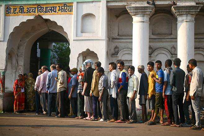 25일(현지시간) 인도 유권자들이 총선 투표를 위해 투표소에서 줄을 서고 있다. [AFP]