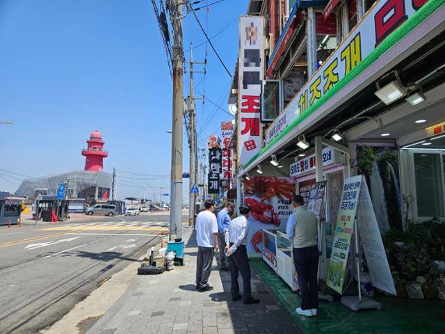 23일 점심시간대 경기 시흥시 정왕동 오이도해양단지에서 횟집 사장과 관광객이 얘기를 나누고 있다. 이종구 기자