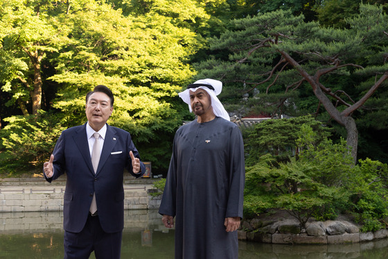 President Yoon Suk Yeol, left, and United Arab Emirates (UAE) President Mohamed bin Zayed Al Nahyan chat as they take a stroll through Changdeok Palace in Jongno District, central Seoul, on Tuesday. [PRESIDENTIAL OFFICE]