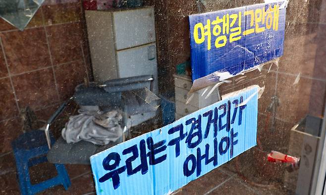 지난 9일 경기 파주시 용주골 농성장 창문에 붙어 있는 ‘여행길’ 반대 팻말이다. 파주시청은 성매매&nbsp;집결지 폐쇄에 대한 공감대를 형성할 목적으로 용주골 내를 걸어보는 프로그램 ‘여행길’을 진행하고 있다. 파주=최상수 기자