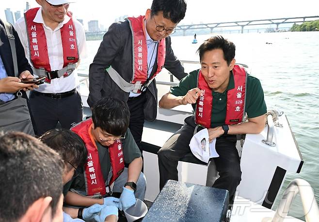 오세훈 서울시장이 '제1회 쉬엄쉬엄 한강 3종 축제'에 앞서 29일 오후 광진구 뚝섬한강공원 일대를 찾아, 한강 수질 검사를 위해 시료를 채취한 보건환경연구원 관계자들과 대화를 나누고 있다.(서울시 제공)ⓒ 뉴스1