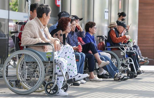 정부의 의대 정원 증원에 반발해 전공의들이 병원을 떠난 지 100일째 되는 29일 서울의 한 대학병원에서 환자들이 건물 밖에서 진료를 기다리고 있다.