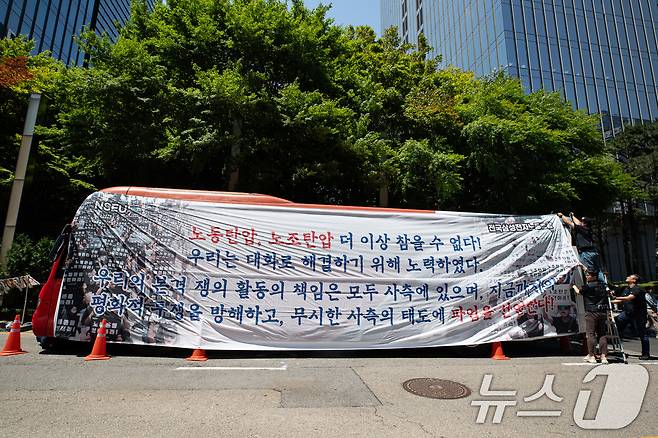 전국삼성전자노동조합 조합원들이 29일 서울 강남구 삼성전자 서초사옥 앞에서 파업 선언 기자회견을 마친 후 대형버스에 현수막을 매다는 퍼포먼스를 하고 있다. 삼성전자 최대 노조인 전국삼성전자노조는 삼성전자 창사 이후 첫 파업을 선언하며 "사측이 교섭 조건을 받아들이지 않아 즉각 파업에 임한다"며 "모든 책임은 노조를 무시하는 사측에 있다"고 주장했다. 2024.5.29/뉴스1 ⓒ News1 유승관 기자