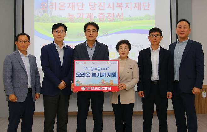 29일 충남 당진시복지재단에서 열린 농기계 기증식에서 권혁용 오리온 AGRO팀 상무, 최범림 오리온재단 사무국장, 강도순 당진시 순성농협 조합장, 양기림 당진시복지재단 이사장, 신낙현 당진시청 농식품유통과장, 유광근 당진시해나루조합공동사업법인 대표(왼쪽부터)가 기념사진을 촬영하고 있다.(오리온 제공)