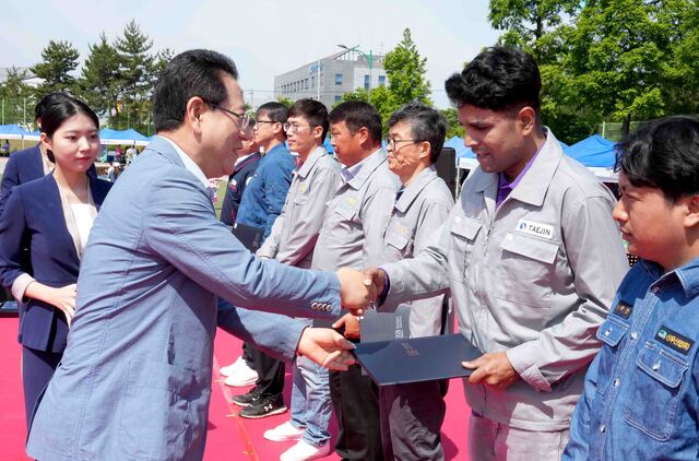 김영록 전라남도지사가 2일 대불종합체육관에서 열린 ‘2024 전라남도 대불산단 조선업 내·외국인 한마당’ 행사에서 모범근로자들에게 표창을 수여하고 기념촬영을 하고 있다. 전남도 제공