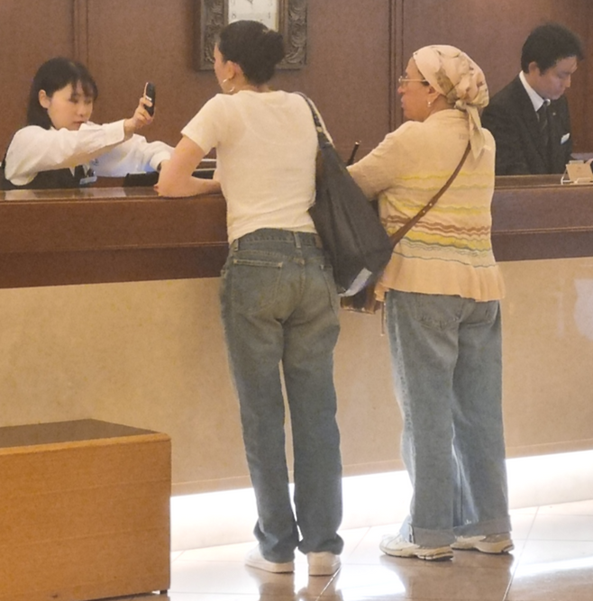 일본 도쿄 시내 한 호텔에서 한 직원이 ‘포켓 토크’를 활용해 외국인 투숙객과 대화를 나누는 모습. [사진 = 방영덕 기자]