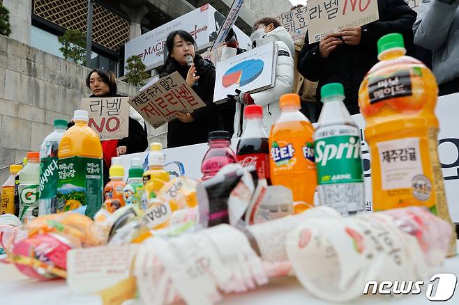 서울환경연합과 대구환경연합 자원순환프로젝트팀 ‘쓰레기고객센터’ 회원들이 지난해 11월 29일 서울 종로구 세종문화회관 계단에서 플라스틱 병입음료 제조 판매 기업을 향해 무라벨 정책 도입을 촉구하는 기자회견을 하고 있다. /뉴스1 ⓒ News1 안은나 기자