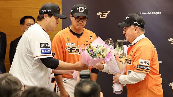 취임식 후 류현진, 채은성으로부터 꽃다발을 받고 있는 김경문 감독(오른쪽)