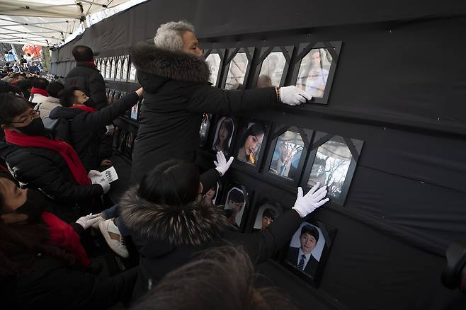 이태원 참사 100일을 하루 앞둔 2023년 2월4일 유가족과 시민들이 서울시청 앞에 기습적으로 분향소를 만든 뒤 영정사진을 설치하고 있다. ⓒ시사IN 이명익