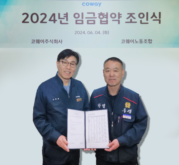 4일 충청남도 공주시 유구공장에서 진행된 2024년 임금협약 조인식에서 김동화(왼쪽) 코웨이 생산본부장과 임재환 생산 코웨이노동조합 위원장이 기념촬영을 하고 있다. [사진=코웨이]