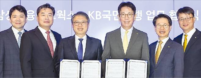 삼성금융네트웍스와 국민은행이 4일 서울 태평로 삼성 본관에서 상호 협력을 위한 업무협약을 맺었다. 김대환 삼성카드 사장(왼쪽 세 번째)과 이재근 국민은행장(네 번째)이 삼성생명·화재·카드·증권, 국민은행 임원들과 함께 협약서를 들어 보이고 있다.  삼성금융 제공