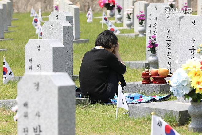 5일 서울 동작구 국립서울현충원을 찾은 참배객이 남편의 묘 앞에 앉아 눈물 흘리고 있다.
