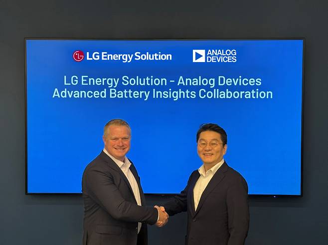 Roger Keen (left), general manager of battery management systems at Analog Devices, Inc., and Lee Dal-hoon, vice president and head of the battery management solution research and development center at LG Energy Solution, shake hands at the partnership ceremony on Tuesday at ADI's headquarters in Boston, Massachusetts. (LG Energy Solution)