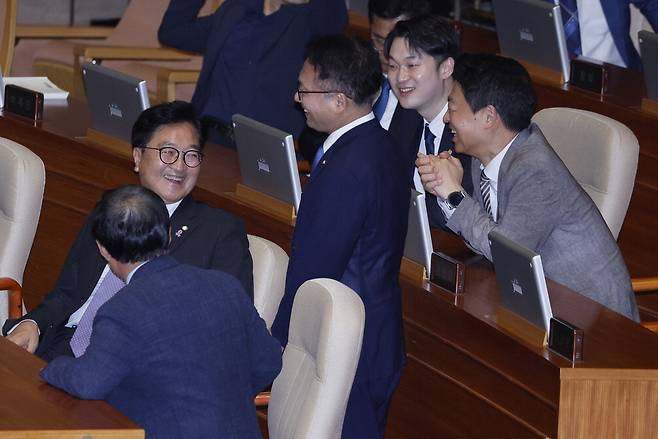 우원식 더불어민주당 의원(왼쪽)이 5일 국회 본회의에서 22대 국회 전반기 국회의장으로 선출된 뒤 민주당 의원들의 축하를 받으며 환하게 웃고 있다. 뉴스1