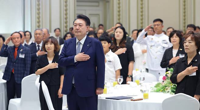 윤석열 대통령이 6일 청와대 영빈관에서 열린 국가유공자 및 보훈가족 초청 오찬에서 국기에 경례하고 있다.(사진=연합뉴스)