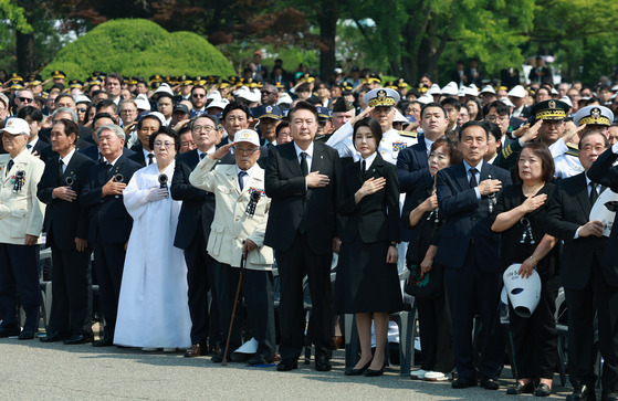 President Yoon Suk Yeol, seventh from left in the front row, places his hand over his chest during a Memorial Day ceremony to honor South Korea's veterans and fallen soldiers at Seoul National Cemetery in Dongjak District, southern Seoul, on Thursday. [JOINT PRESS CORPS]