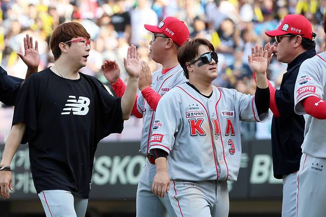 KIA 양현종(왼쪽)과 김선빈이 6일 광주 기아챔피언스필드에서 열린 2024 프로야구 롯데와 경기에서 승리한 뒤 코칭스태프와 하이파이브를 하고 있다.   광주 | 연합뉴스