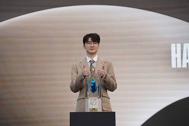 Lee "Faker" Sang-hyeok makes his iconic "thumbs-up" pose with the Hall of Legends trophy at The Shilla Seoul in Jung-gu, central Seoul, Thursday. (Riot Games)