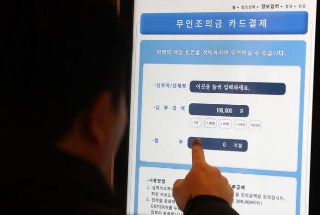 한 남성이 '무인 조의금 키오스크'로 조의금을 납부하고 있다. 특이사항은 카드 결제 할부가 된다는 점이다. 6개월까지. /연합뉴스