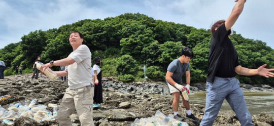 박정오(왼쪽) 사단법인 큰샘 대표가 7일 인천 강화군 일대에서 북한 서해안으로 보내기 위해 준비한 쌀을 던지고 있다. 사단법인 큰샘 제공