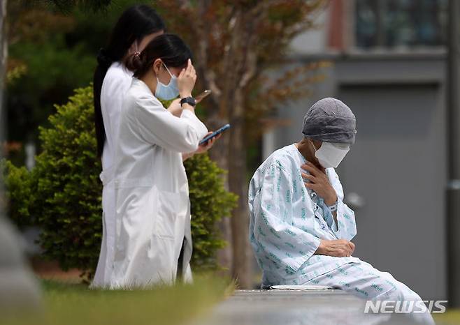 [서울=뉴시스] 김명년 기자 = 서울대학교 의과대학 교수들이 오는 17일부터 응급·중환자실을 제외하고 전체 휴진을 결정한 가운데 7일 오후 서울 종로구 서울대학교병원에서 한 환자가 야외의자에  앉아 있다. 2024.06.07. kmn@newsis.com