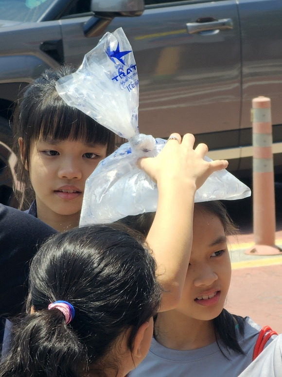 한국 너무 더워요 - 5일 강원 춘천시 중앙로에서 한 외국 어린이가 머리에 얼음주머니를 올려 더위를 피하고 있다.  이날 강원지역 낮 최고 기온은 오후 3시 기준으로 32.3도를 기록했다. 2024.6.5 연합뉴스