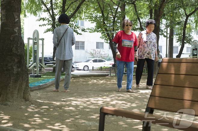 폭염주의보가 내려진 10일 낮 대구의 도심공원에서 시민들이 선글라스와 쿨토시를 착용한 채 맨발로 걷고 있다.2024.6.10/뉴스1 ⓒ News1 이성덕 기자