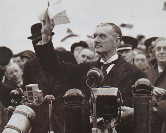 아돌프 히틀러의 요구대로 체코슬로바키아의 주데텐란트를 나치 독일에 넘기는 내용의 뮌헨협정에 서명한 네빌 체임벌린 영국 총리가 1938년 9월30일 헤스톤 공항으로 귀국한 뒤 마중 나온 군중 앞에서 협정문을 보여주고 있다.