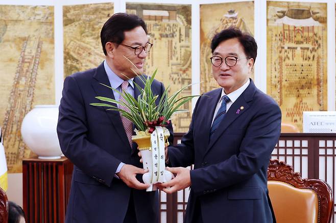 우원식 국회의장(오른쪽)이 10일 오전 국회의장실을 예방한 정진석 대통령 비서실장으로부터 윤석열 대통령이 보낸 축하난을 전달받고 있다. ⓒ연합뉴스