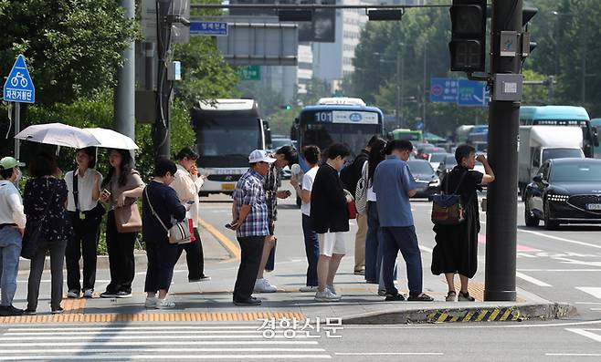 11일 서울 광화문 사거리 횡단보도에서 시민들이 가르등이 만들어준 그늘을 따라 늘어선 채 햇볕을 피하고 있다. 정지윤 선임기자