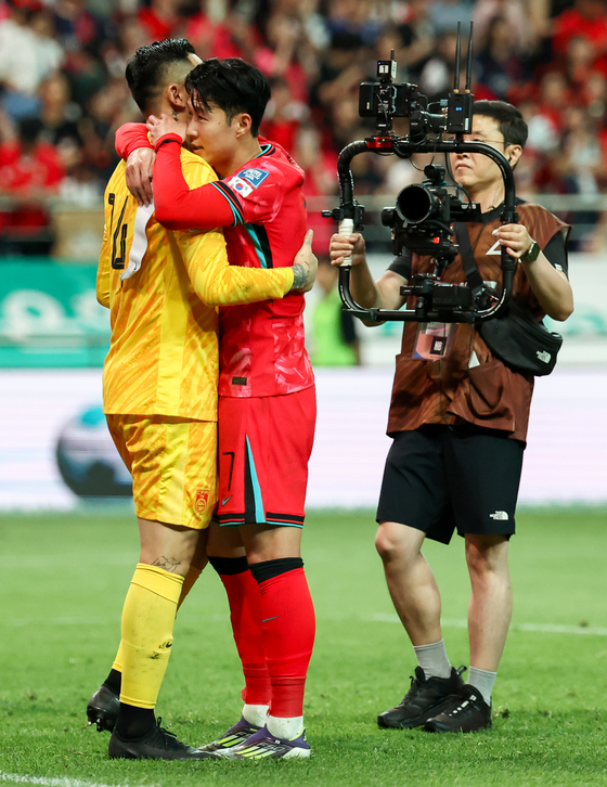 Korea captain Son Heung-min, right, hugs China goalkeeper and captain Wang Dalei after Korea beat China 1-0 in the final second round 2026 World Cup qualifying match at Seoul World Cup Stadium in western Seoul on Tuesday. [YONHAP]