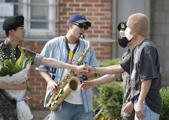 BTS's RM, center, plays "Dynamite" on his saxophone for Jin on Wednesday. [NEWS1]