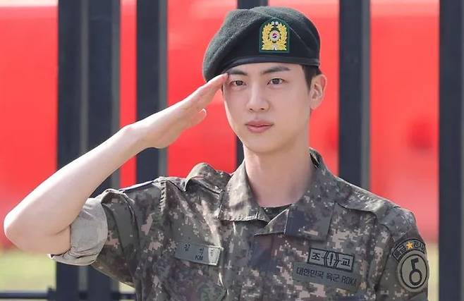 BTS\'s Jin salutes as he is discharged from the military on Wednesday. Yonhap News Agency