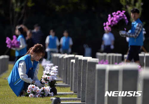 【서울=뉴시스】김선웅 기자 = 20일 오전 서울 동작구 국립서울현충원 26번 묘역에서 농협 대학생 홍보대사 'NH 영서포터즈'가 헌화 및 묘역정화 봉사활동을 하고 있다. 2017.09.20. mangusta@newsis.com