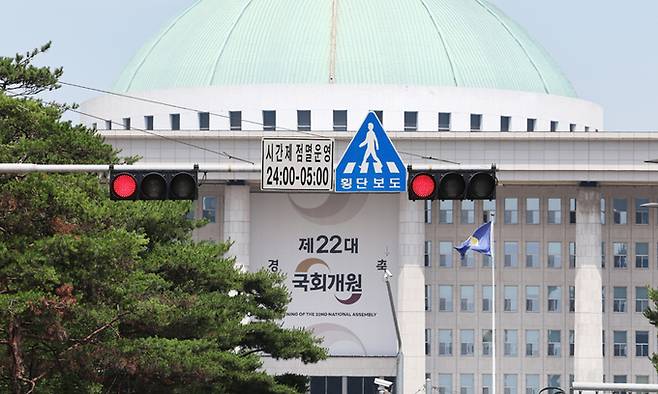 서울 여의도 국회의사당 앞 교통신호등 너머로 22대 국회개원 축하 현수막이 보인다. 연합뉴스