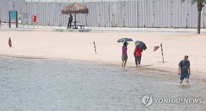 해수욕장 산책 (창원=연합뉴스) 김동민 기자 = 경남지역 낮 최고 기온이 34도까지 예보된 14일 오후 시민들이 경남 창원시 마산합포구 광암해수욕장에서 걷고 있다. 2024.6.14 image@yna.co.kr