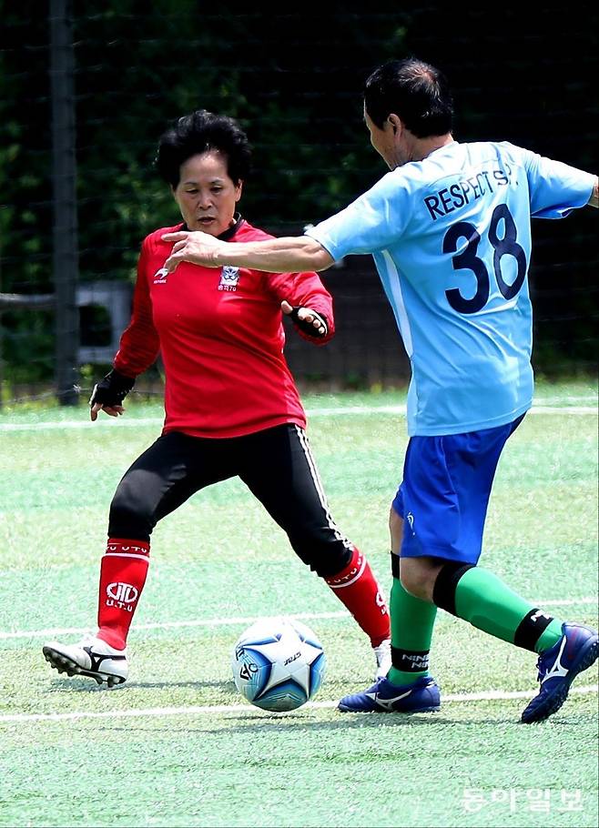 송파구70대축구단의 ‘홍일점’ 정애자 씨(왼쪽)가 서울 송파여성축구장에서  상대 공격수를 막고 있다. 변영욱 기자 cut@donga.com