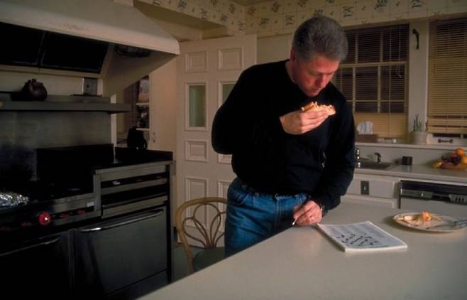 부엌에서 아침을 먹으며 크로스워드 퍼즐을 푸는 빌 클린턴 대통령. 빌 클린턴 대통령 도서관 홈페이지