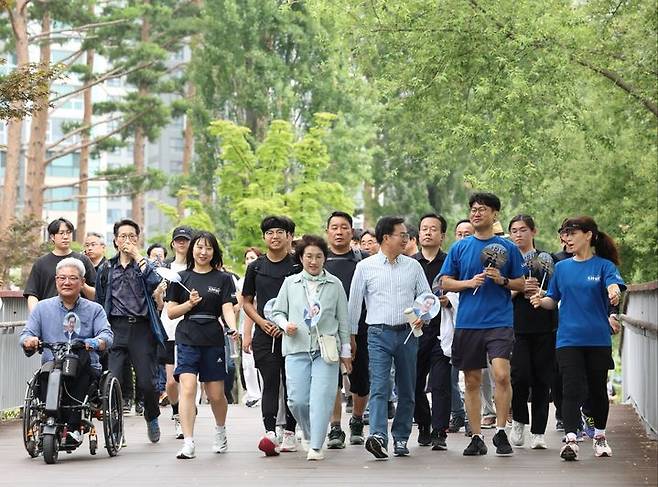 [수원=뉴시스] 김동연 경기도지사가 15일 시민들과 함께 광교호수공원을 걸으며 대화하고 있다. (사진=김동연 경기도지사 SNS) *재판매 및 DB 금지