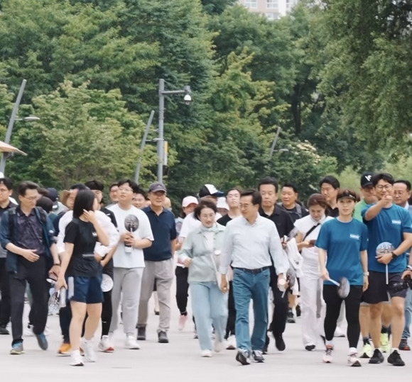 김동연 경기도지사와 정우영 여사가 15일 오전 수원 광교호수공원에서 도민들과 함께 걸으며 소통하고 있다. 김동연 지사 SNS 갈무리