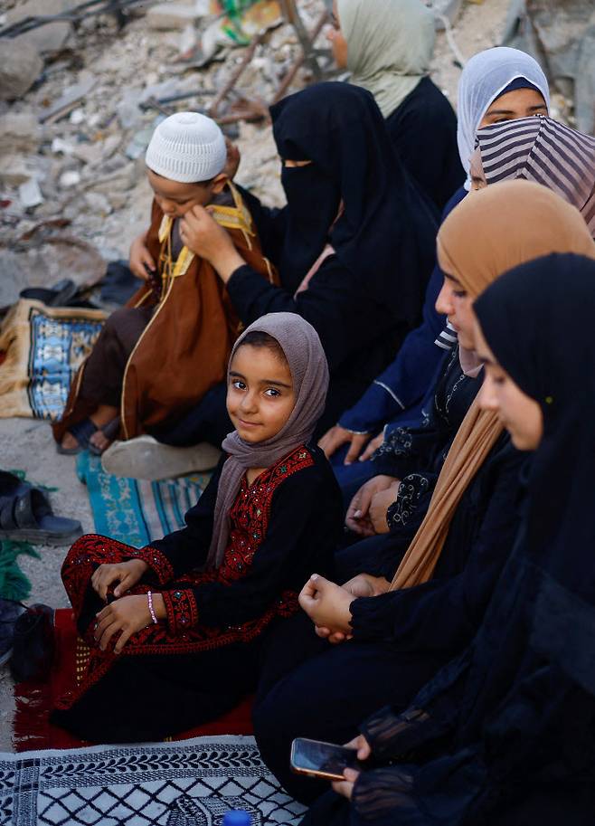 Palestinians hold Eid al-Adha prayers by the ruins of al-Al Rahma mosque destroyed by Israeli air strikes, amid the Israel-Hamas conflict, in Khan Younis, in the southern Gaza Strip, June 16, 2024. REUTERS/Mohammed Salem