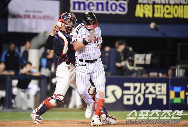 송구 동작에서 오스틴과 부딪힌 롯데 손성빈 포수.