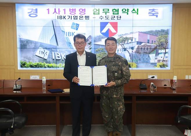 김성태 IBK기업은행장(왼쪽)과 박정택 수도군단 군단장이 17일 육군 수도군단에서 열린 협약식에서 기념촬영을 하고 있다. 기업은행 제공