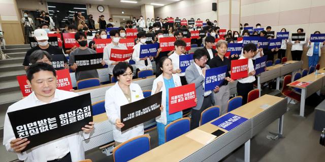 서울대학교 의과대학 교수, 전공의, 의대생들이 17일 오전 서울 종로구 서울대학교 의과대학 융합관 양윤선홀에서 열린 휴진 결의 집회에서 구호를 외치고 있다. 뉴스1