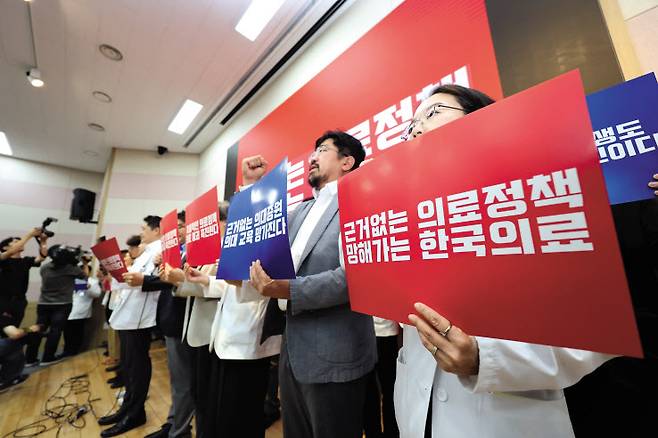 서울대병원 교수들이 전공의 사태 해결 등을 요구하며 무기한 휴진에 들어간 17일 오전 서울 여의도 국회 앞에서 전국의료산업노동조합연맹 관계자 등이 의사 휴진 철회를 촉구하며 퍼포먼스를 하고 있다. 오른쪽 사진은 17일 서울 종로구 서울대학교 의과대학 융합관 양윤선홀에서 구호를 외치고 있는 서울대학교 의과대학 교수, 전공의, 의대생들 [연합]