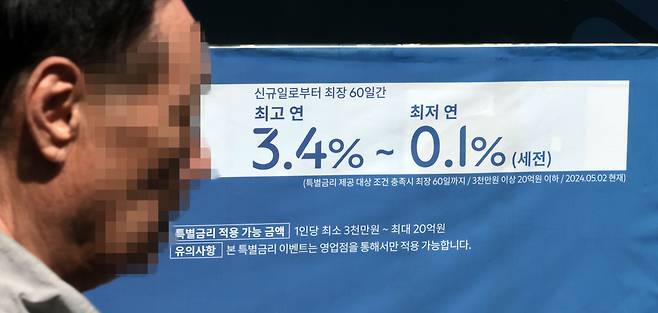 서울 한 시중은행 영업점의 대출 안내문 앞을 시민이 지나가고 있다.[연합]
