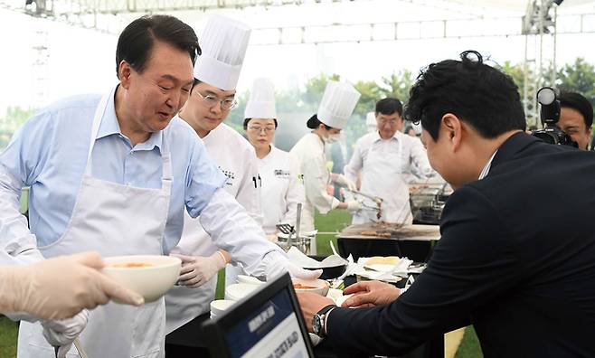 한국언론진흥재단이 내년도 언론인 해외연수 사업을 대폭 확대했다. 윤석열 대통령이 출입기자단과의 간담회에서 언론인 해외연수를 늘리겠다는 취지의 발언을 한 이후에 나온 사업 계획이다. 사진은 윤 대통령이 5월24일 서울 용산 대통령실 잔디마당에서 열린 출입기자단 초청 만찬 간담회에서 김치찌개 등을 배식하고 있는 모습. /대통령실 제공
