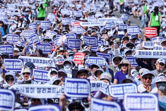 대한의사협회(의협)의 주도로 개원의와 일부 의대 교수들이 집단휴진에 나선 18일 오후 서울 영등포구 여의대로에서 열린 전국 의사 총궐기대회에서 참가자들이 구호를 외치고 있다.연합뉴스