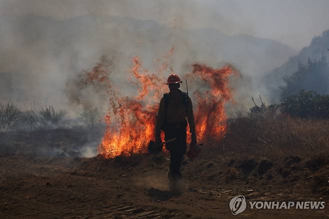 16일(현지시간) 미 LA 서북부에서 산불과 싸우는 소방관 [EPA=연합뉴스. 재판매 및 DB 금지]