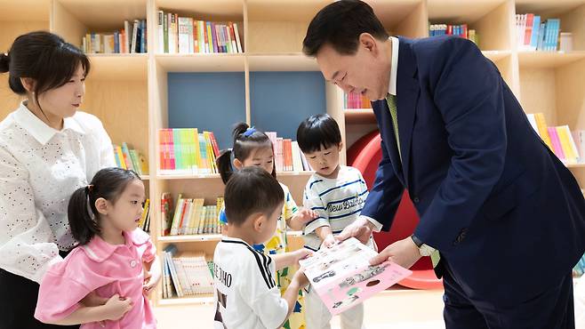 윤석열 대통령이 19일 경기 성남 HD현대 직장어린이집을 방문, 어린이들과 함께 책을 보고 있다./대통령실